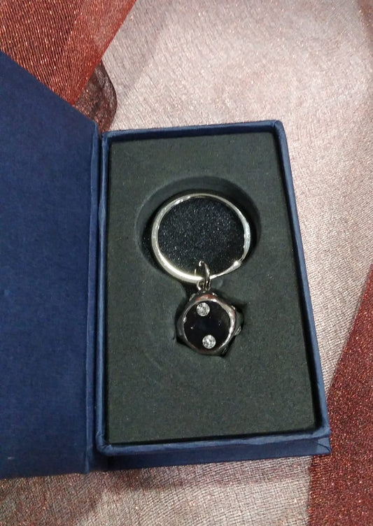 Llavero dado con cristal en caja.